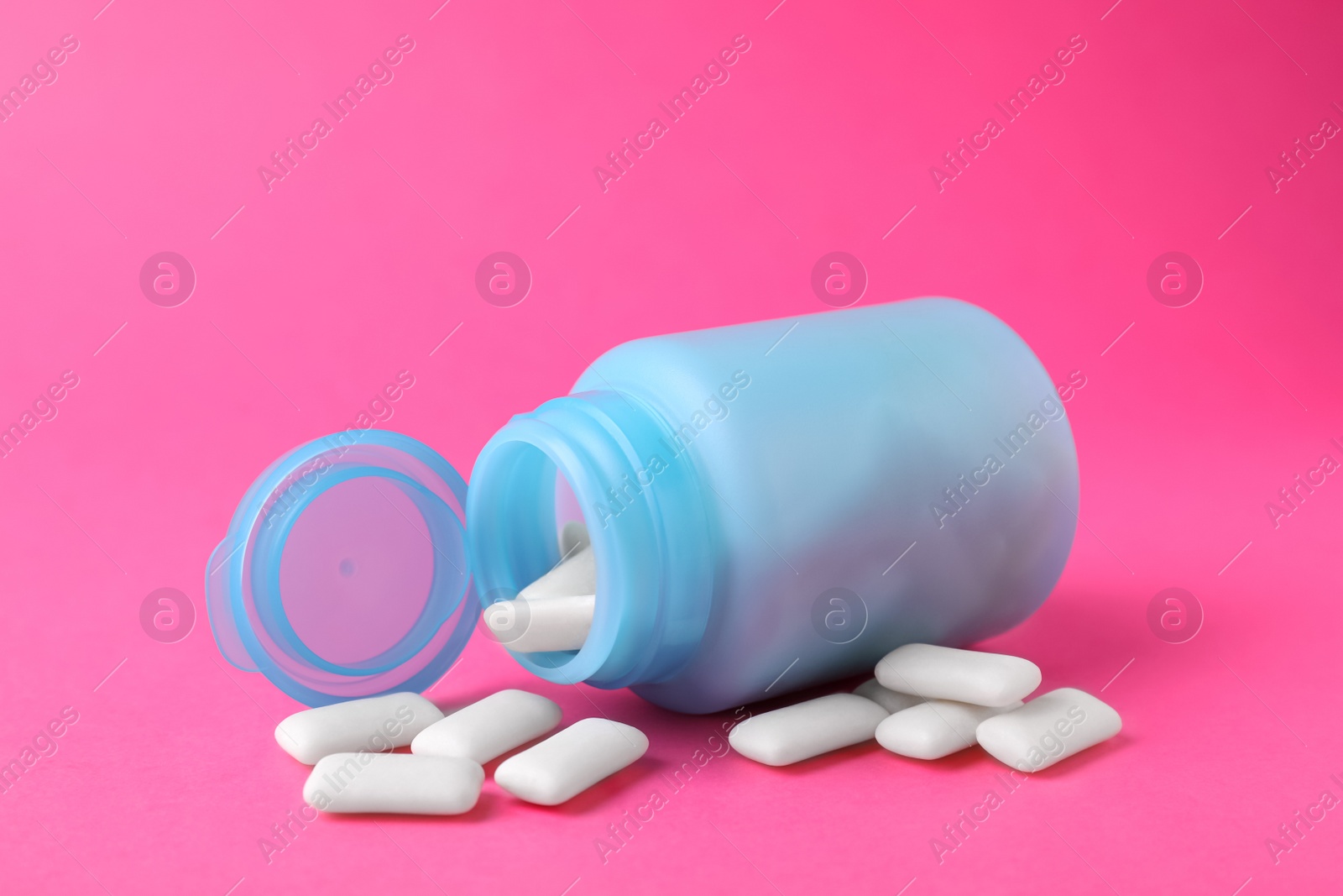 Photo of Jar with chewing gums on pink background