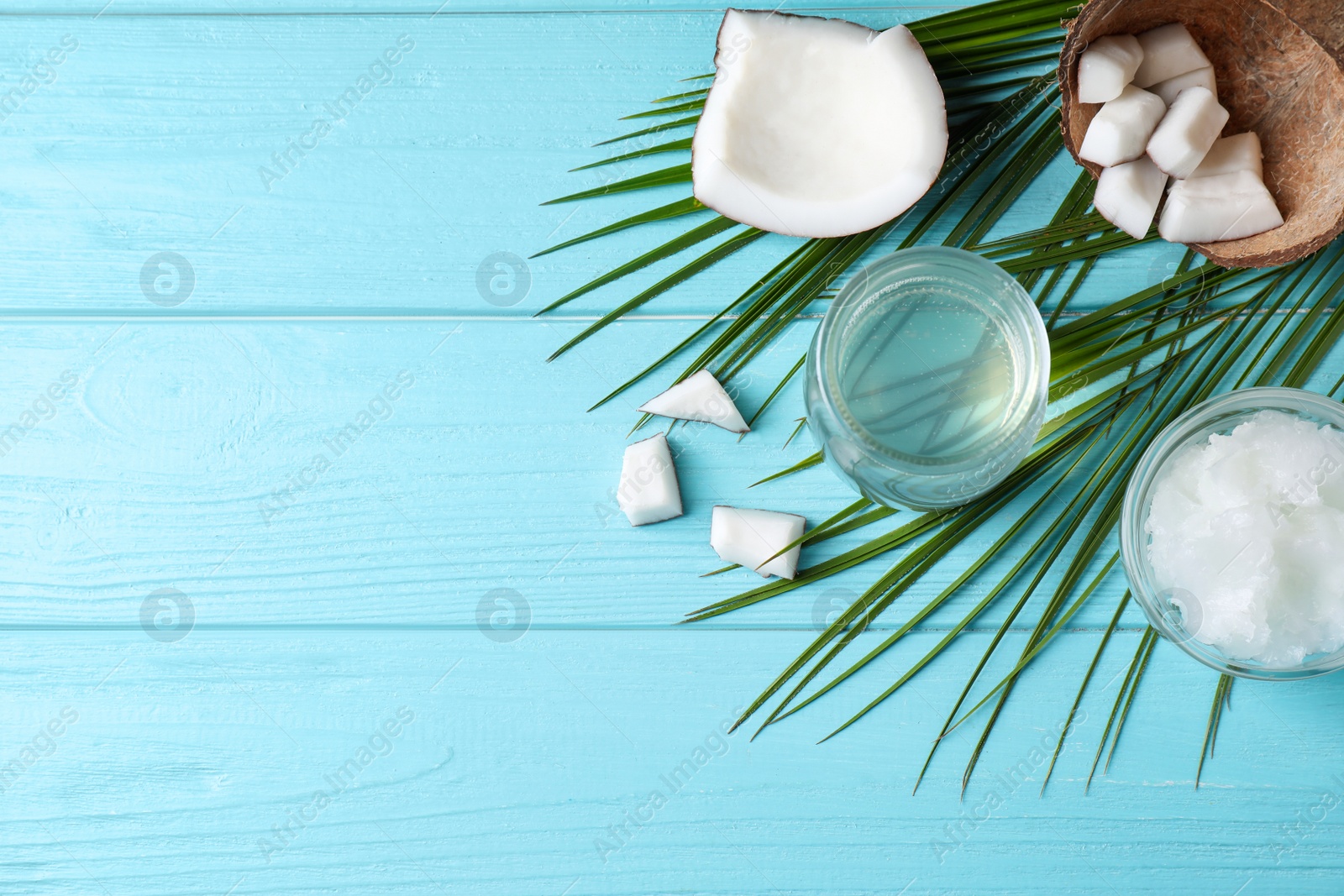 Photo of Flat lay composition with coconut oil on light blue wooden table, space for text