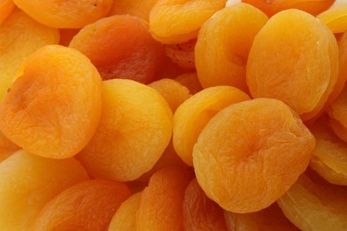 Tasty dried apricots as background, top view
