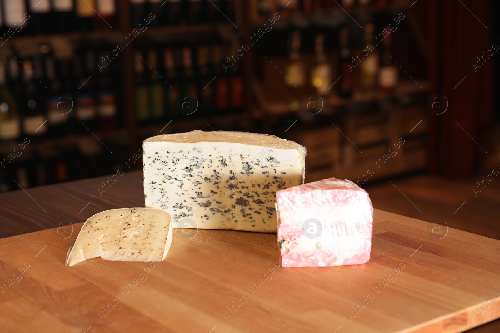 Photo of Different types of delicious cheeses on counter in store