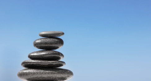 Stack of stones against blue sky, space for text. Zen concept