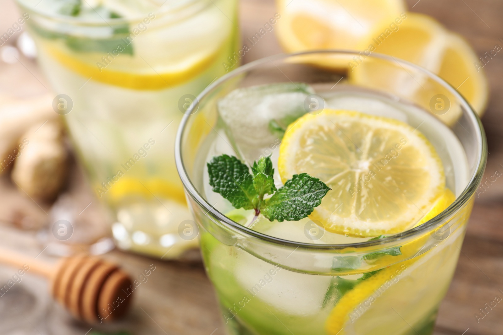 Photo of Glass of refreshing drink with lemon and mint on wooden table, closeup view. Space for text