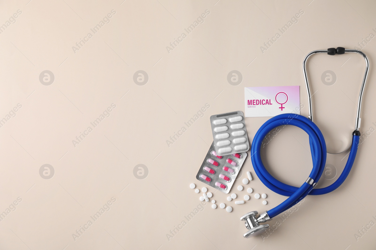 Photo of Flat lay composition with stethoscope and pills on beige background, space for text. Gynecology concept