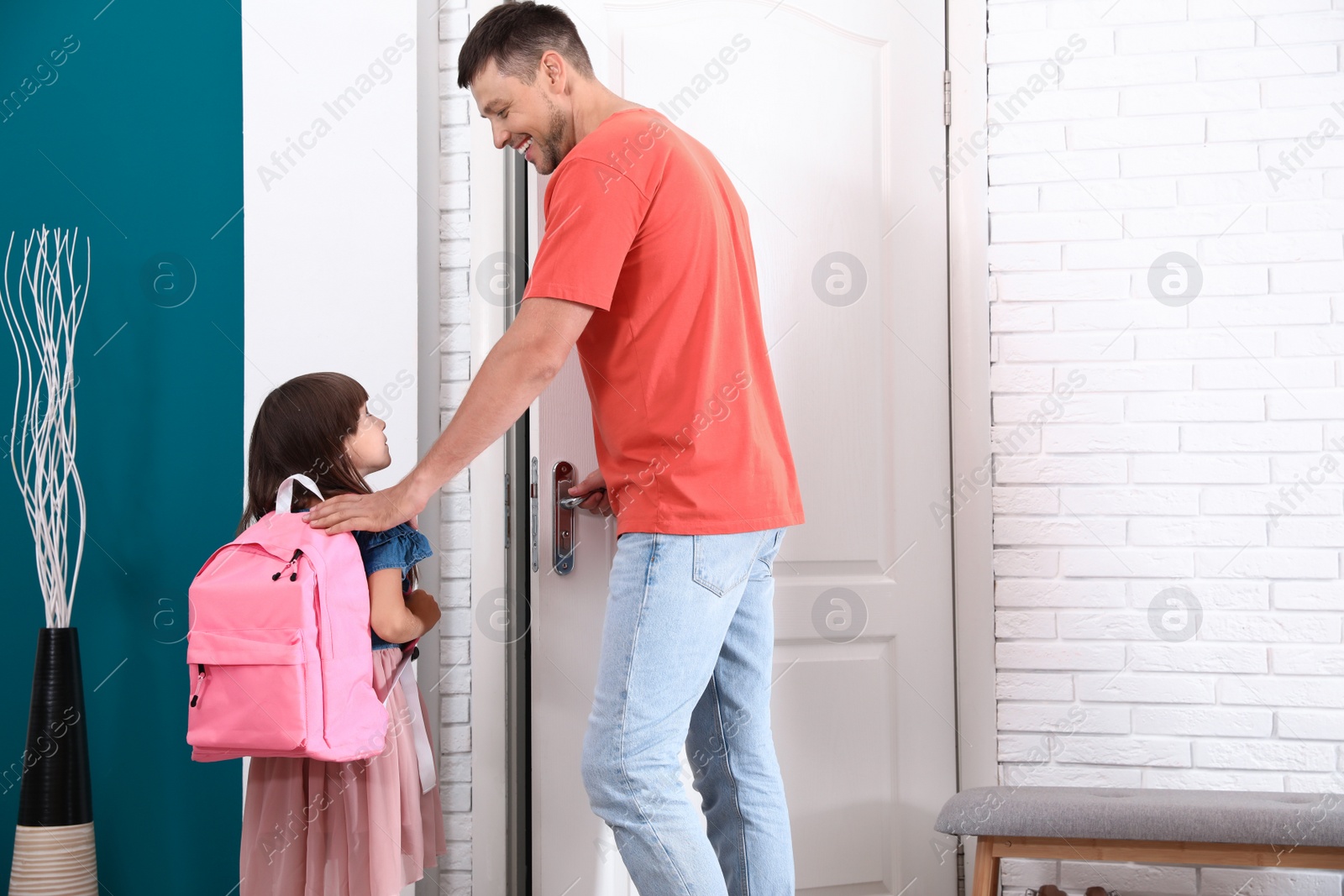 Photo of Happy father and little child with school bag in hallway