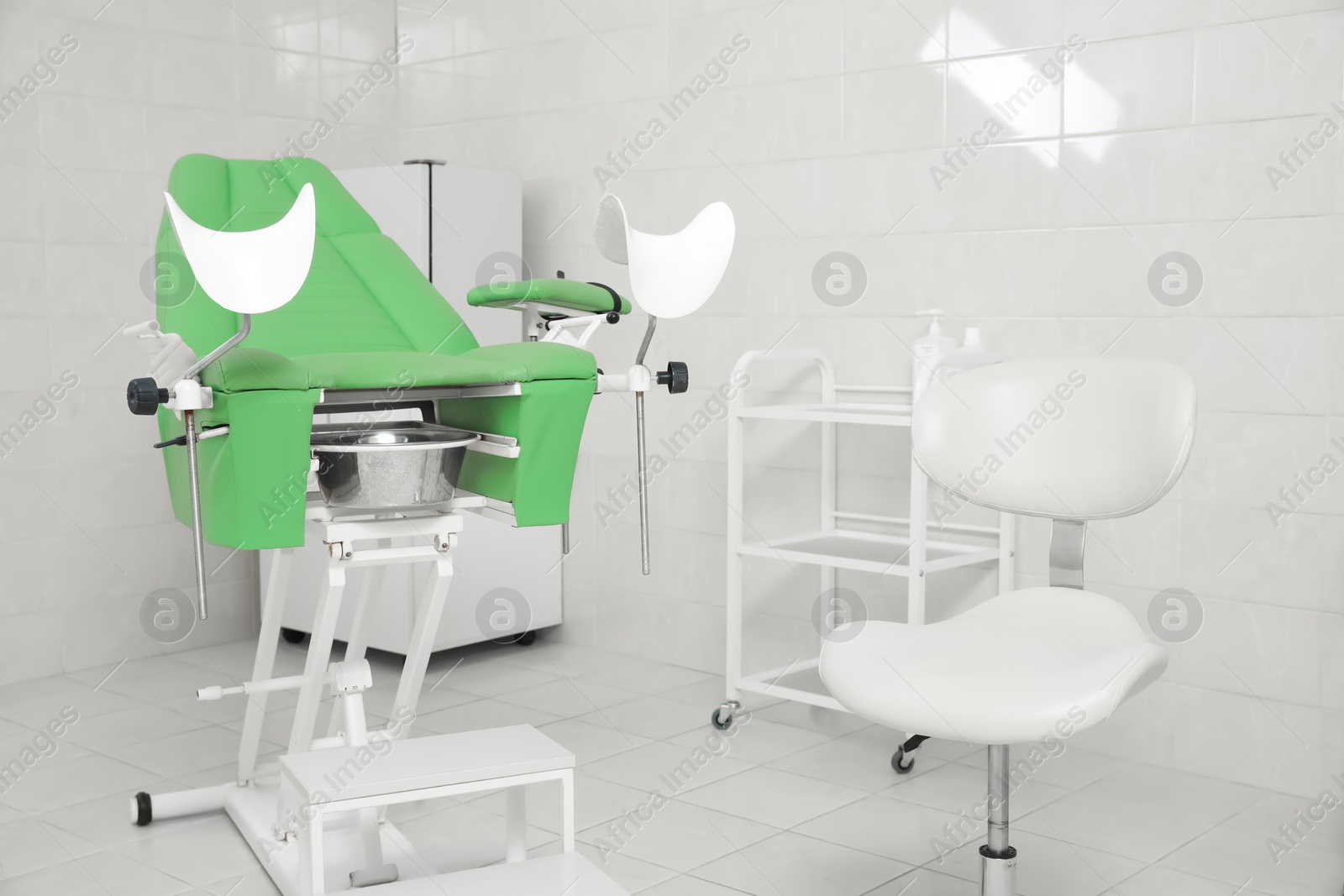 Photo of Modern gynecological office interior with examination chair and medical equipment