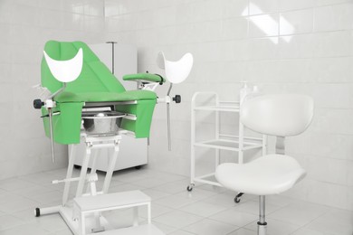 Photo of Modern gynecological office interior with examination chair and medical equipment