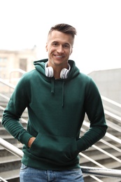 Photo of Portrait of handsome young man with headphones outdoors