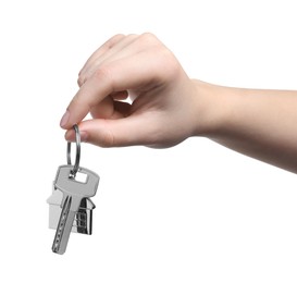 Woman holding key with keychain in shape of house isolated on white, closeup
