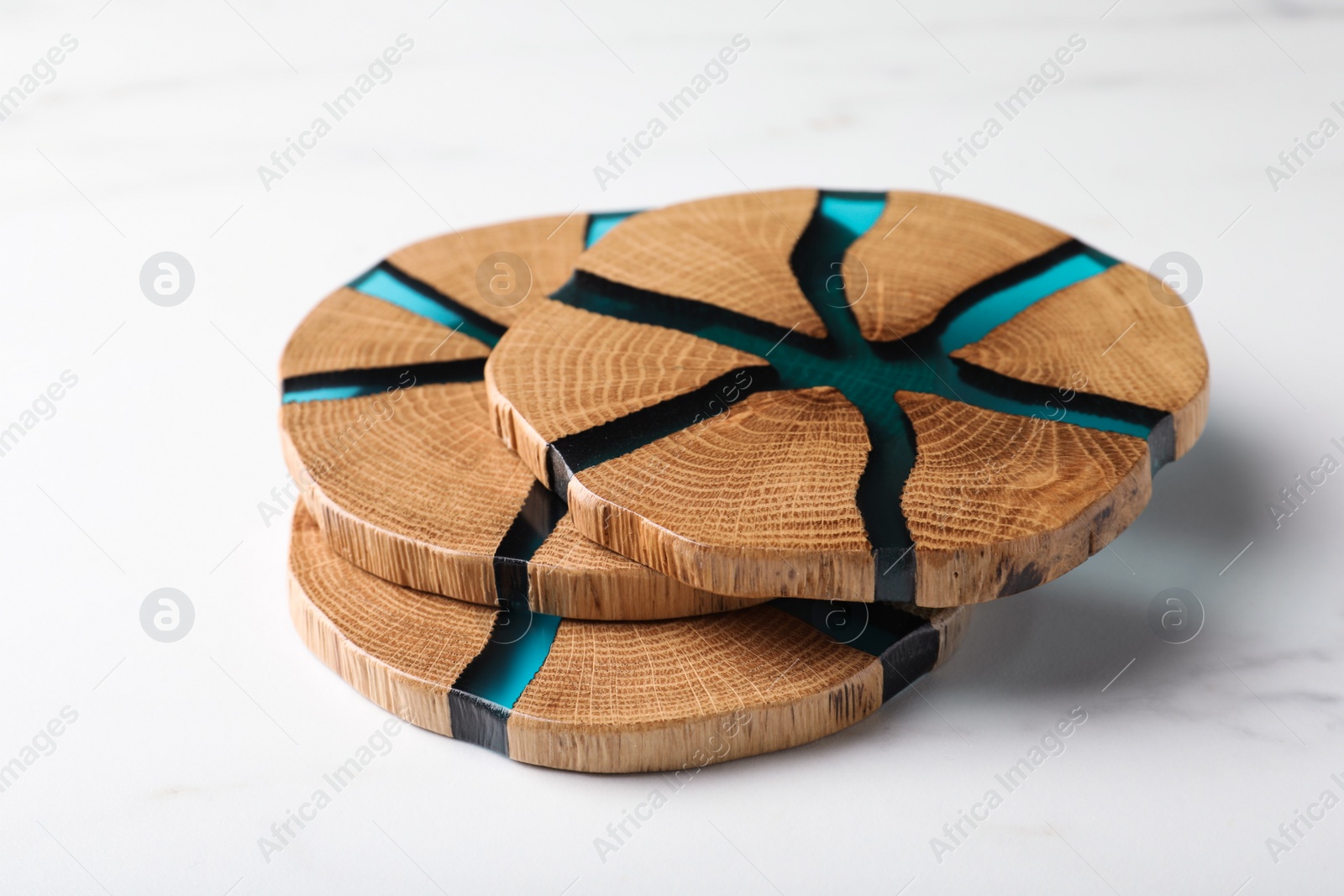 Photo of Stylish wooden cup coasters on white marble table