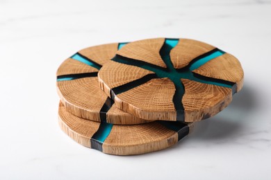 Stylish wooden cup coasters on white marble table