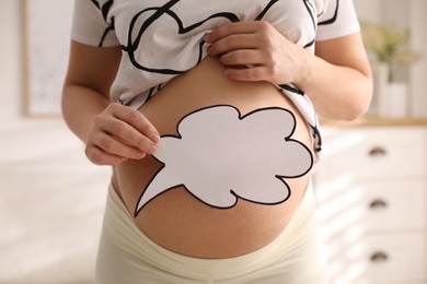 Photo of Pregnant woman with empty paper thought cloud indoors, closeup. Choosing baby name