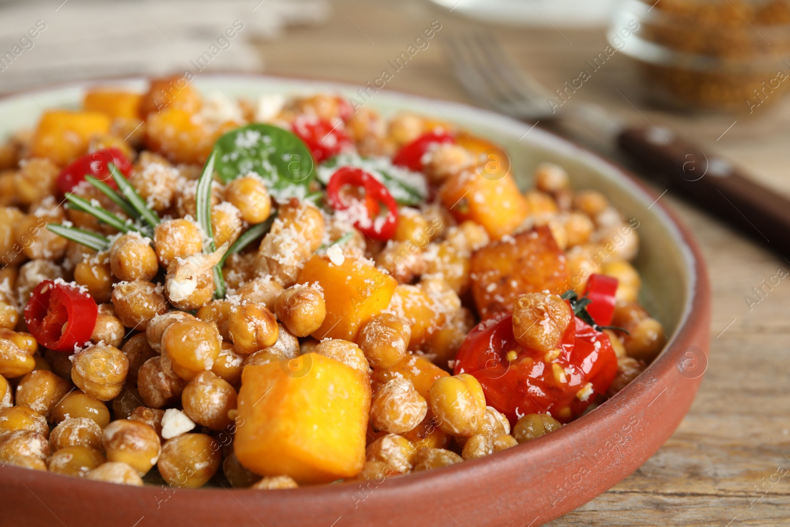 Photo of Delicious fresh chickpea salad on wooden table, closeup