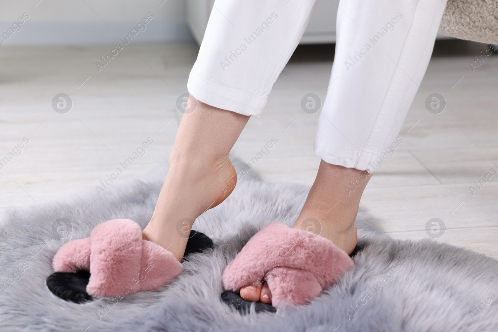 Photo of Woman in soft slippers at home, closeup