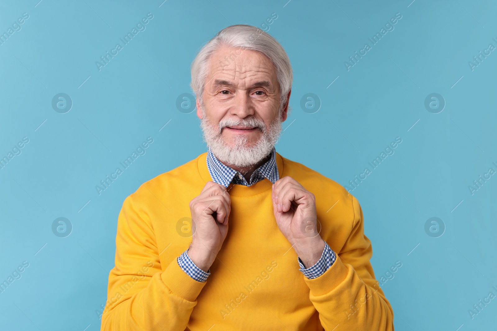 Photo of Portrait of stylish grandpa on light blue background