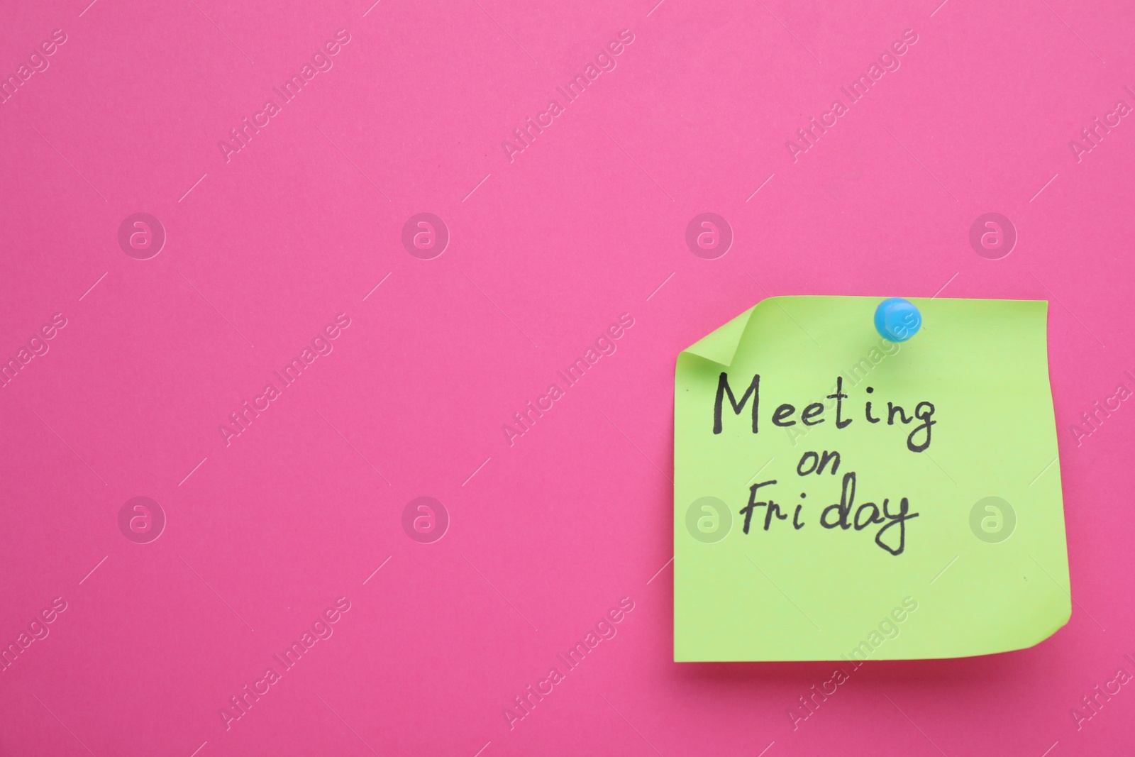 Photo of Paper note with words Meeting on Friday pinned to pink background, space for text