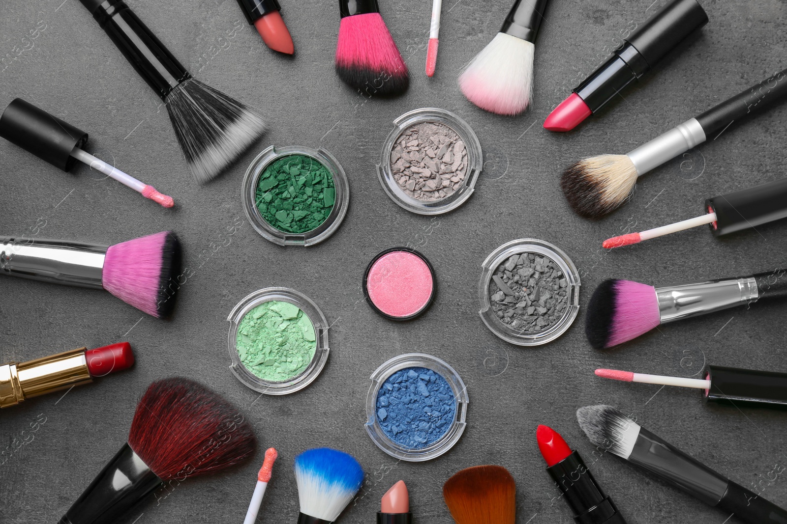 Photo of Flat lay composition with cosmetic products and makeup brushes on grey background