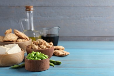 Different organic soy products on light blue wooden table. Space for text