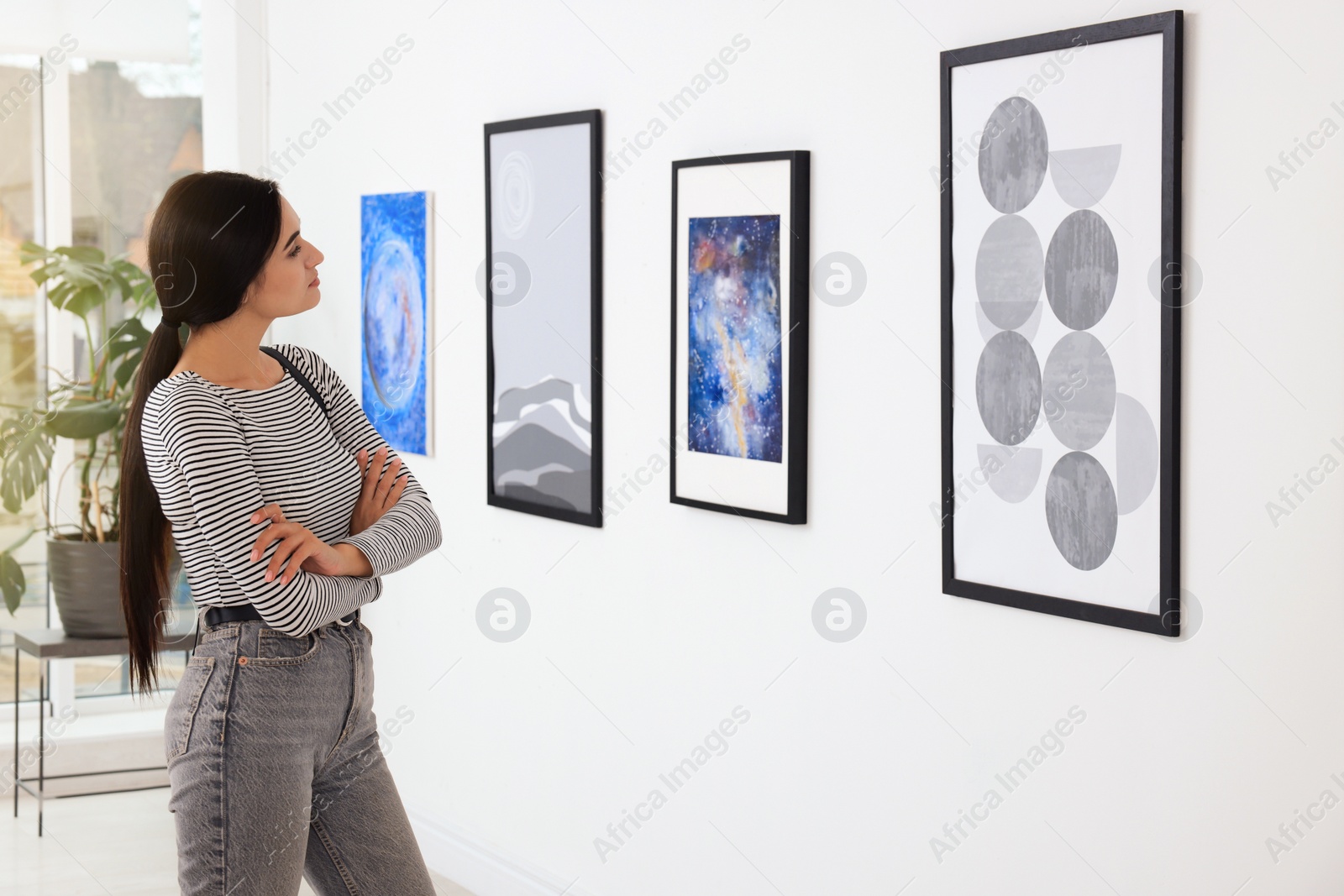 Photo of Thoughtful young woman at exhibition in art gallery