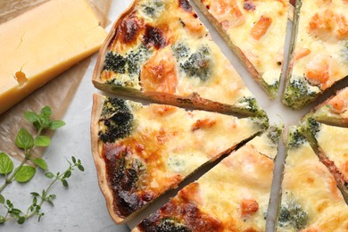 Photo of Delicious homemade quiche and ingredients on table, flat lay