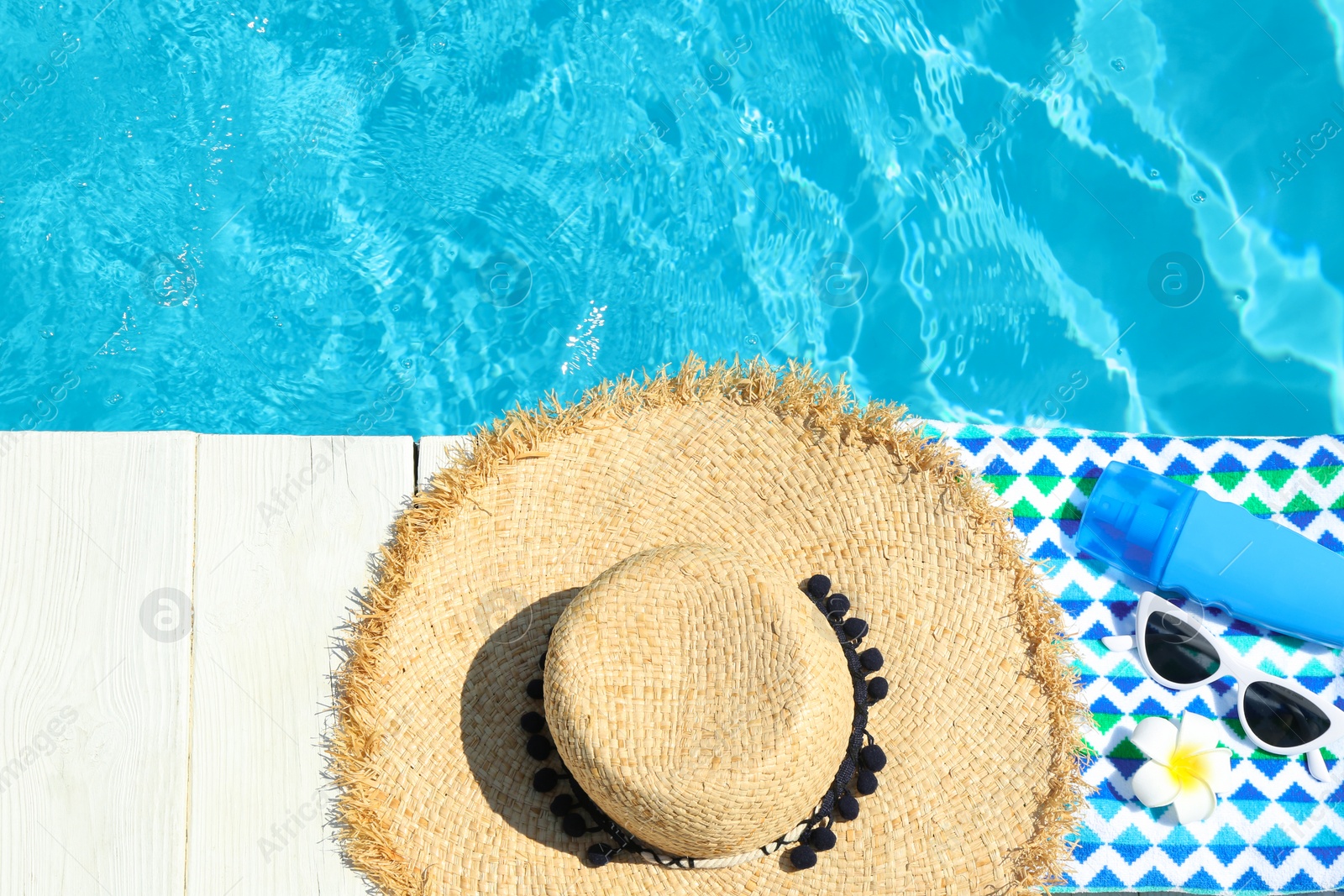 Photo of Flat lay composition with beach accessories on wooden deck near swimming pool. Space for text