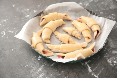 Photo of Baking dish with raw croissants on table