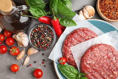 Photo of Flat lay composition with raw meat cutlets for burger on marble table