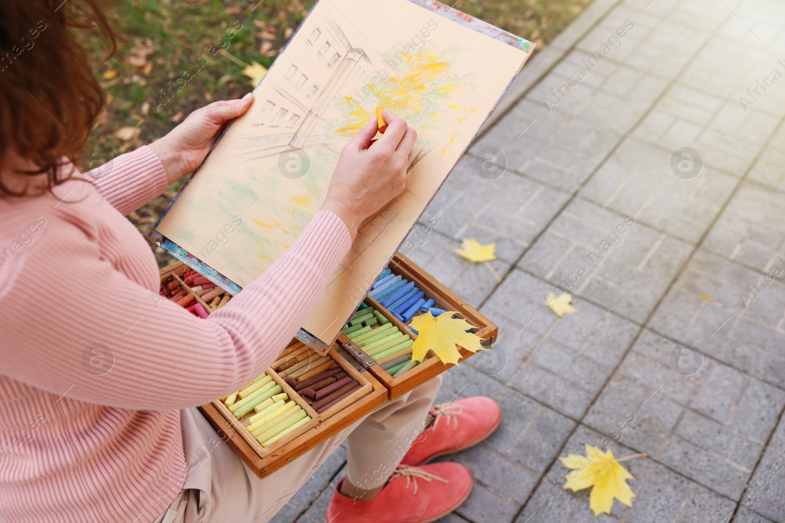 Photo of Woman drawing with soft pastels on street, closeup