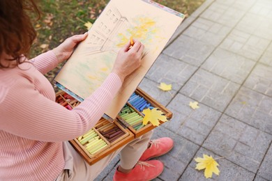 Photo of Woman drawing with soft pastels on street, closeup