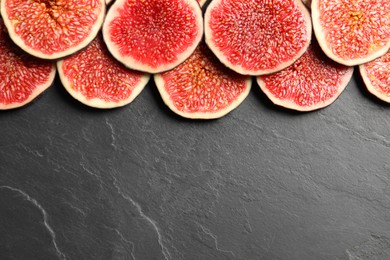 Pieces of fresh ripe figs on grey textured table, flat lay. Space for text