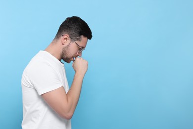 Photo of Man coughing on light blue background, space for text. Sore throat