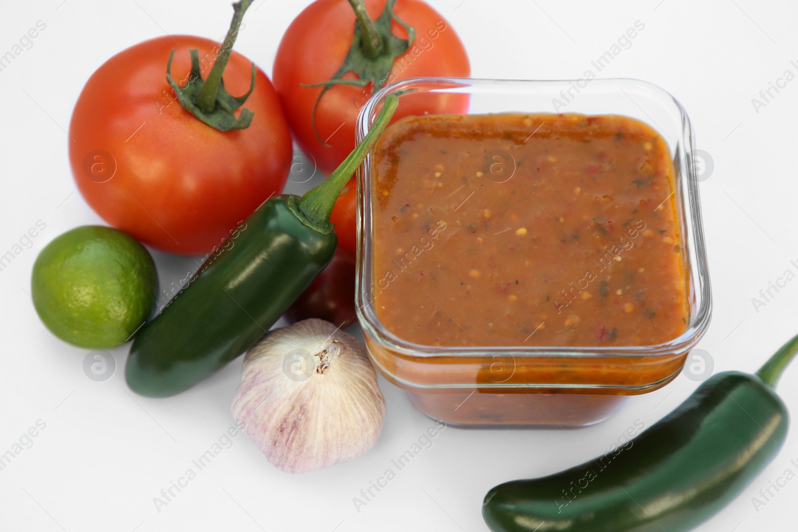 Photo of Delicious salsa sauce and ingredients on white background, closeup