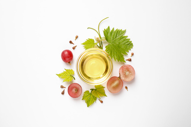 Photo of Composition with bowl of natural grape seed oil on white background, top view. Organic cosmetic