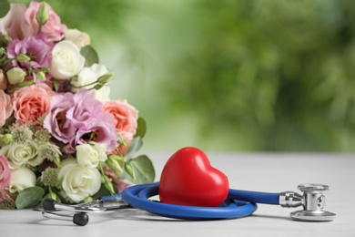 Photo of Composition with red heart and stethoscope on white table against blurred background. World health day