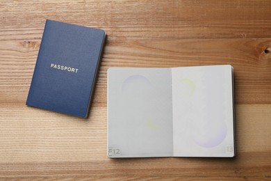 Blank passports on wooden table, flat lay