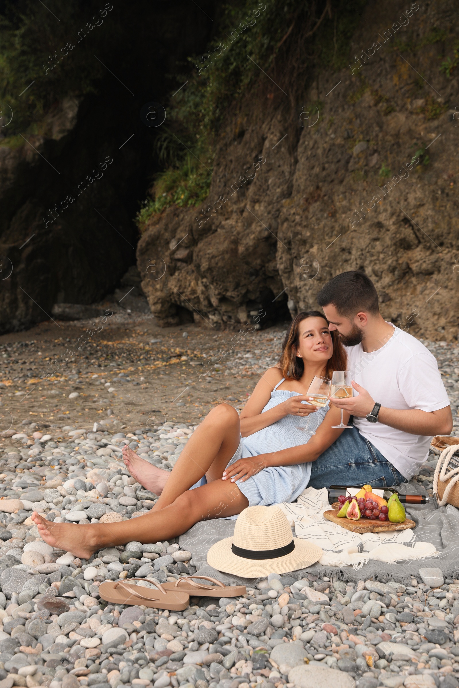 Photo of Happy young couple having picnic on beach