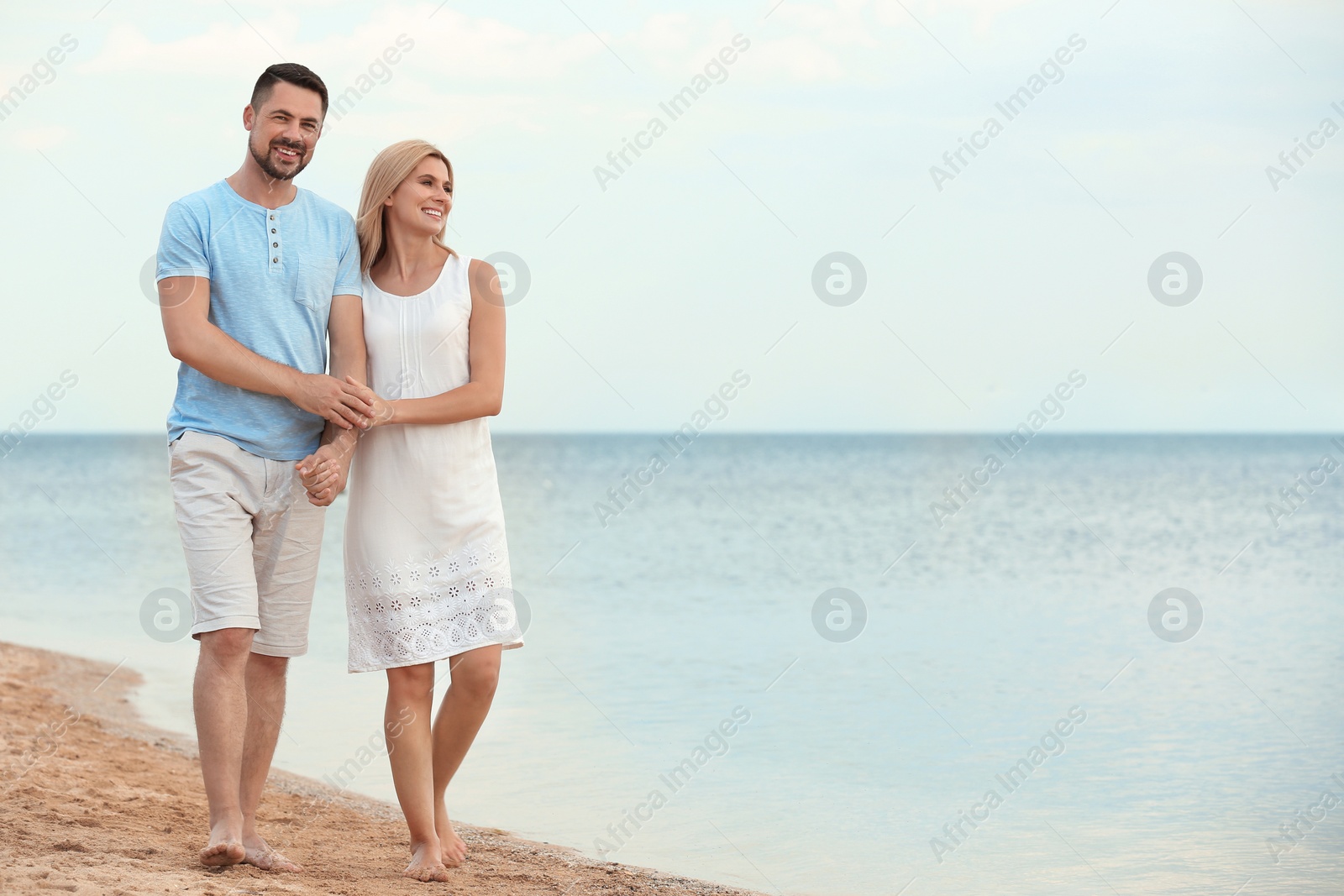 Photo of Happy romantic couple walking on beach, space for text