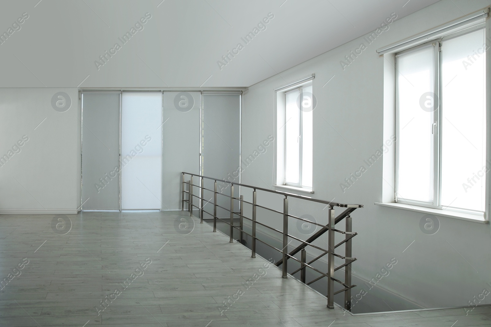 Photo of Large empty hall with windows and railings