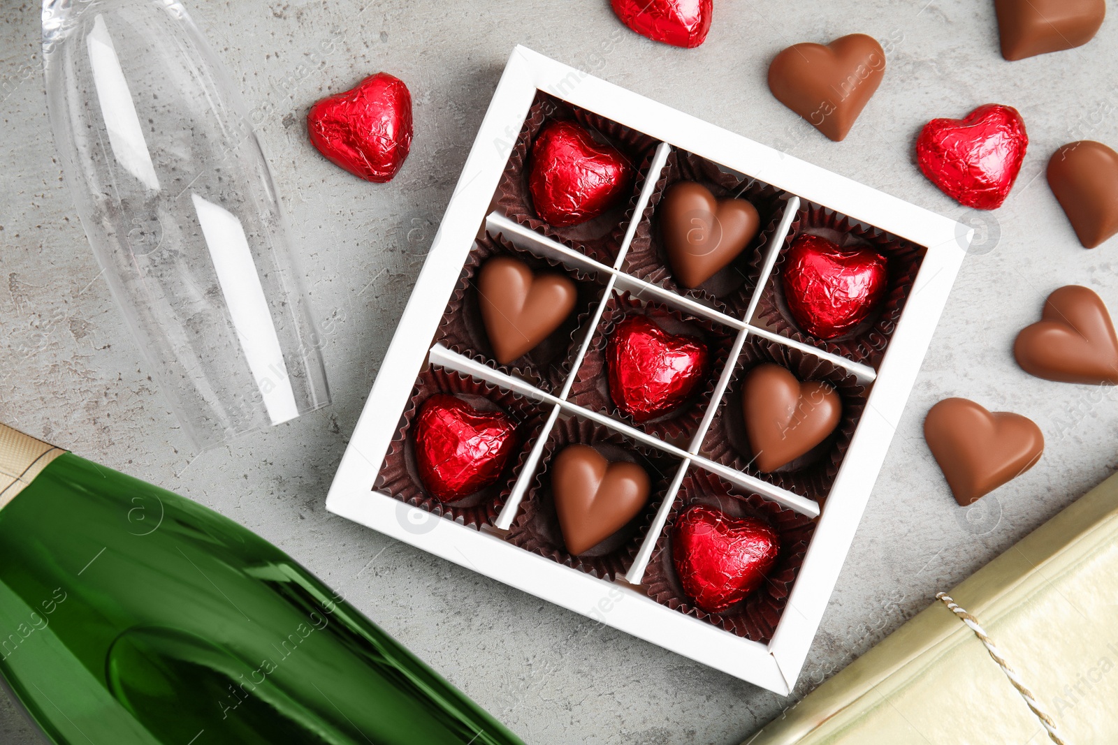 Photo of Flat lay composition with heart shaped chocolate candies on light grey table. Happy Valentine's day