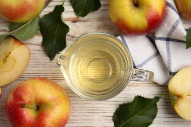 Natural apple vinegar and fresh fruits on white wooden table, flat lay