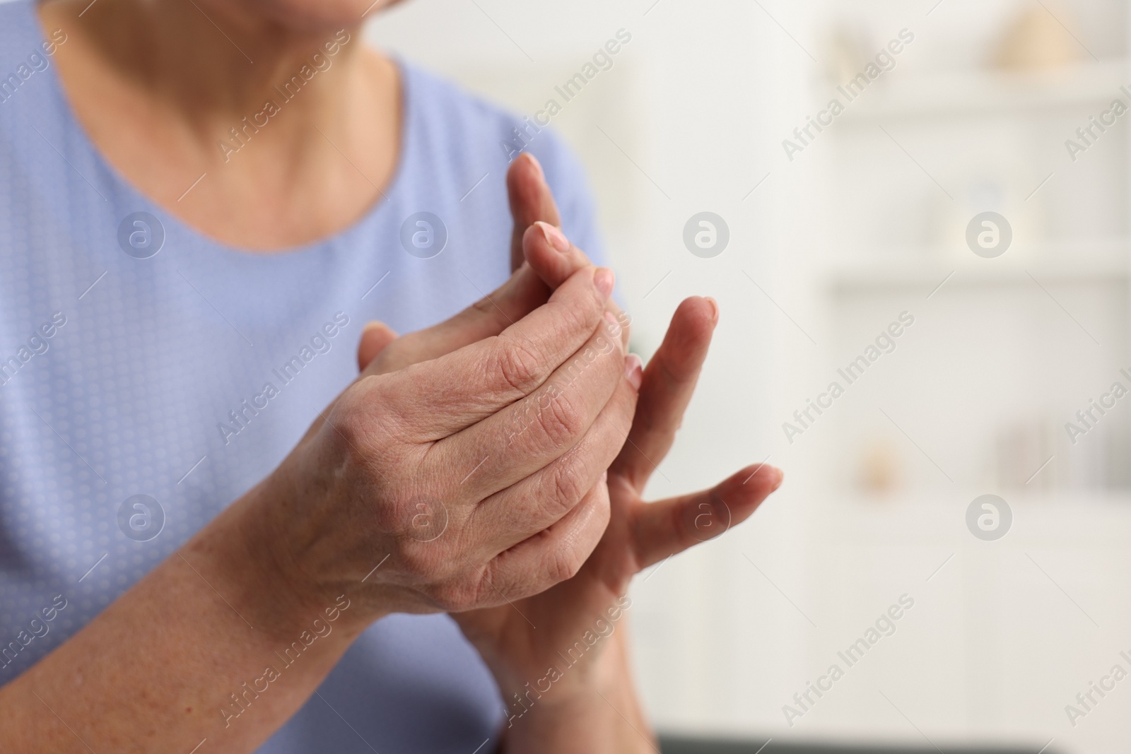 Photo of Arthritis symptoms. Woman suffering from pain in finger at home, closeup