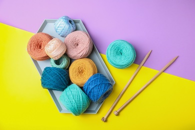 Photo of Flat lay composition with knitting threads and needles on color background