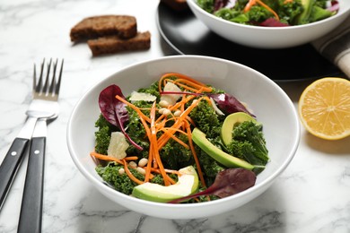 Tasty fresh kale salad on marble table