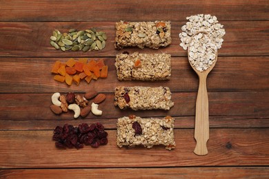 Different tasty granola bars and ingredients on wooden table, flat lay