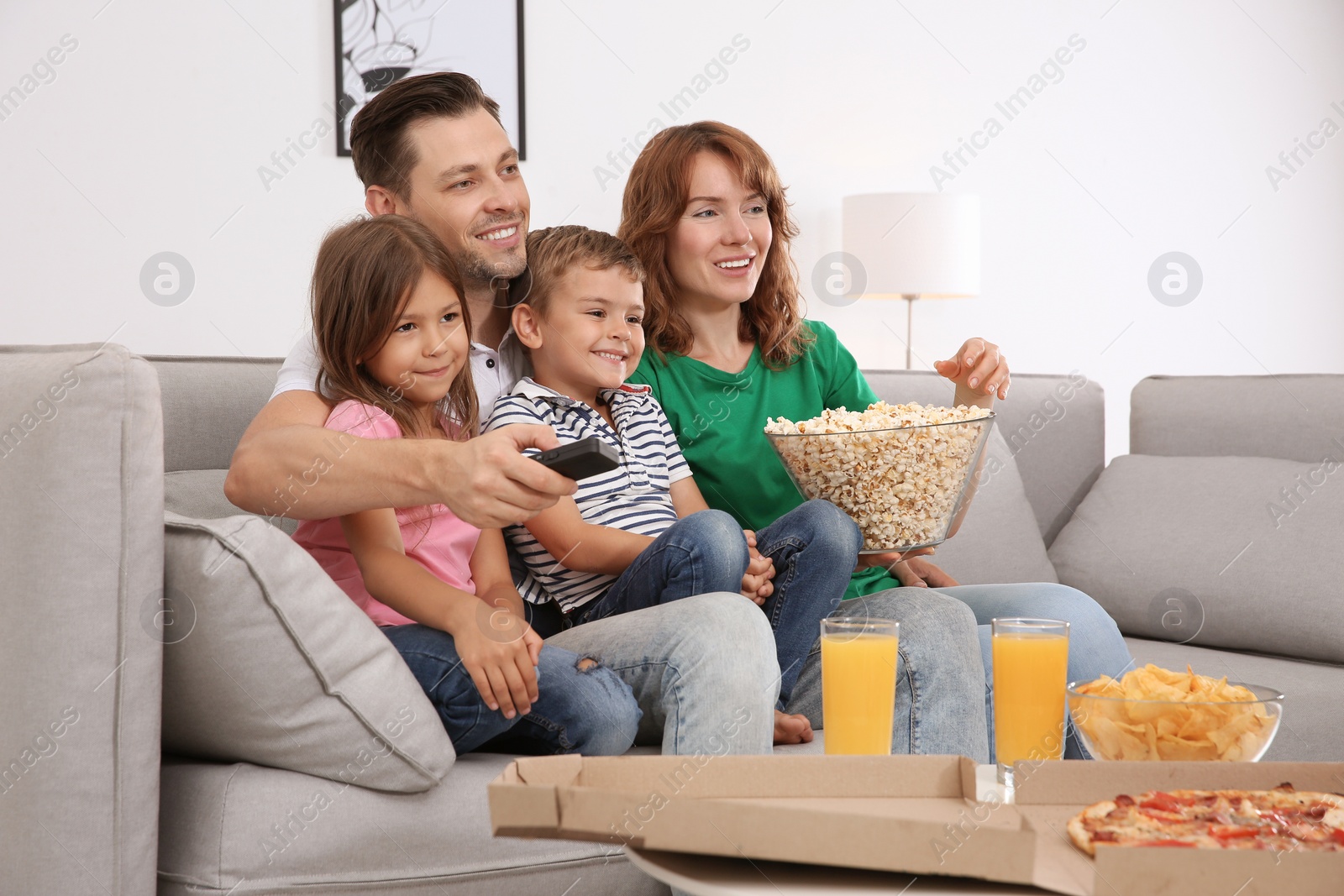 Photo of Family watching TV with popcorn in room