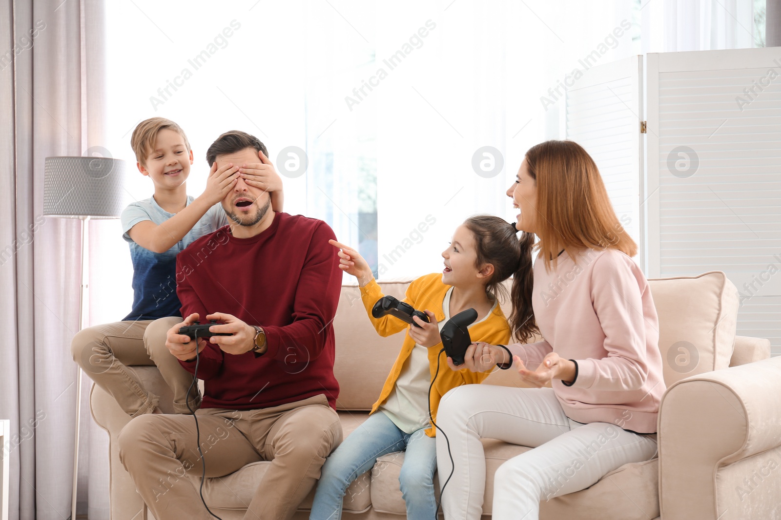 Photo of Happy family playing video games in living room