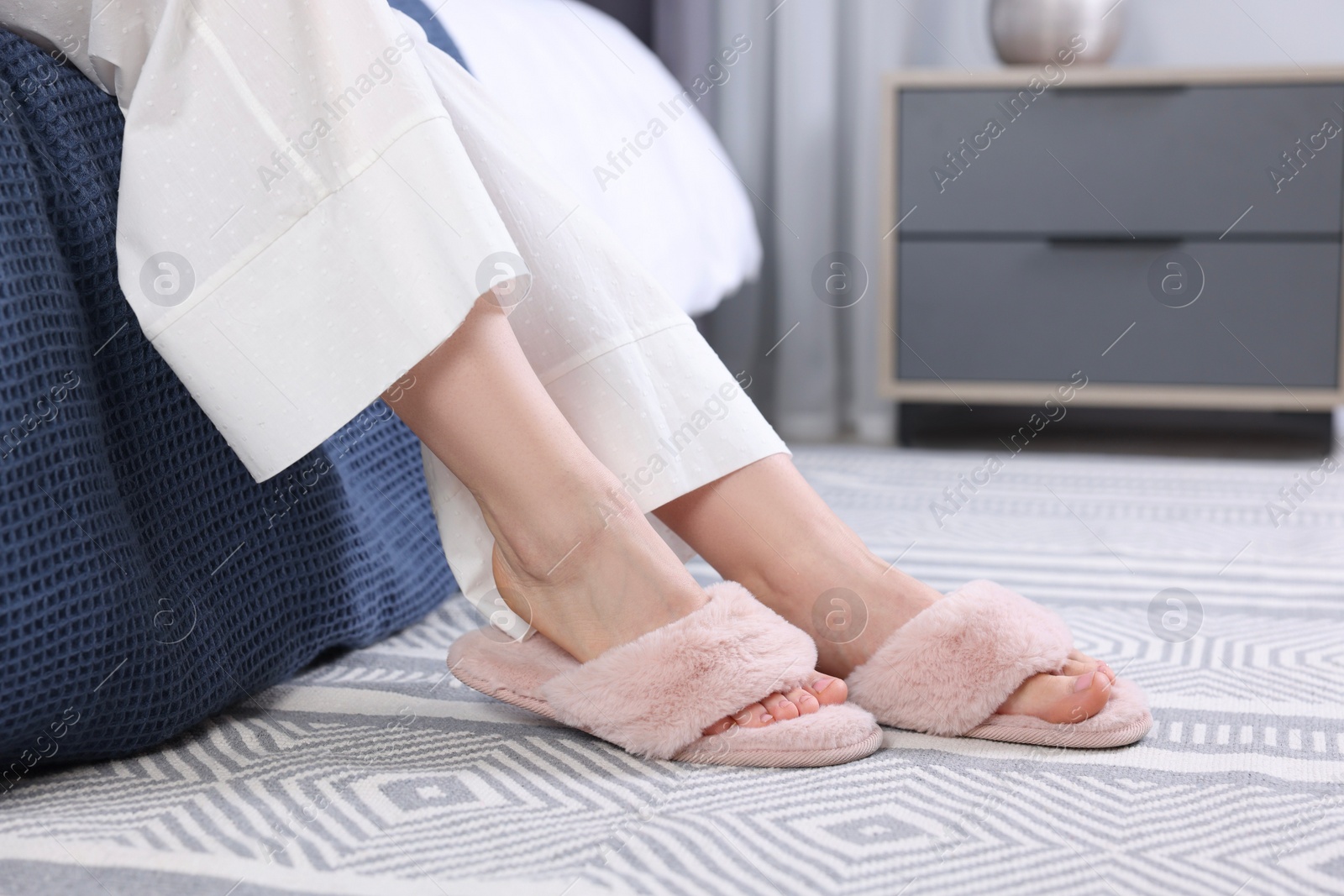 Photo of Woman in pink soft slippers at home, closeup