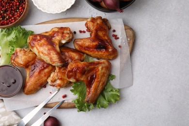 Photo of Flat lay composition with marinade, chicken wings and other products on light table. Space for text