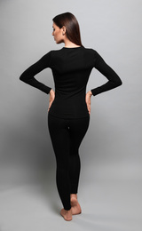 Photo of Woman wearing thermal underwear on grey background, back view