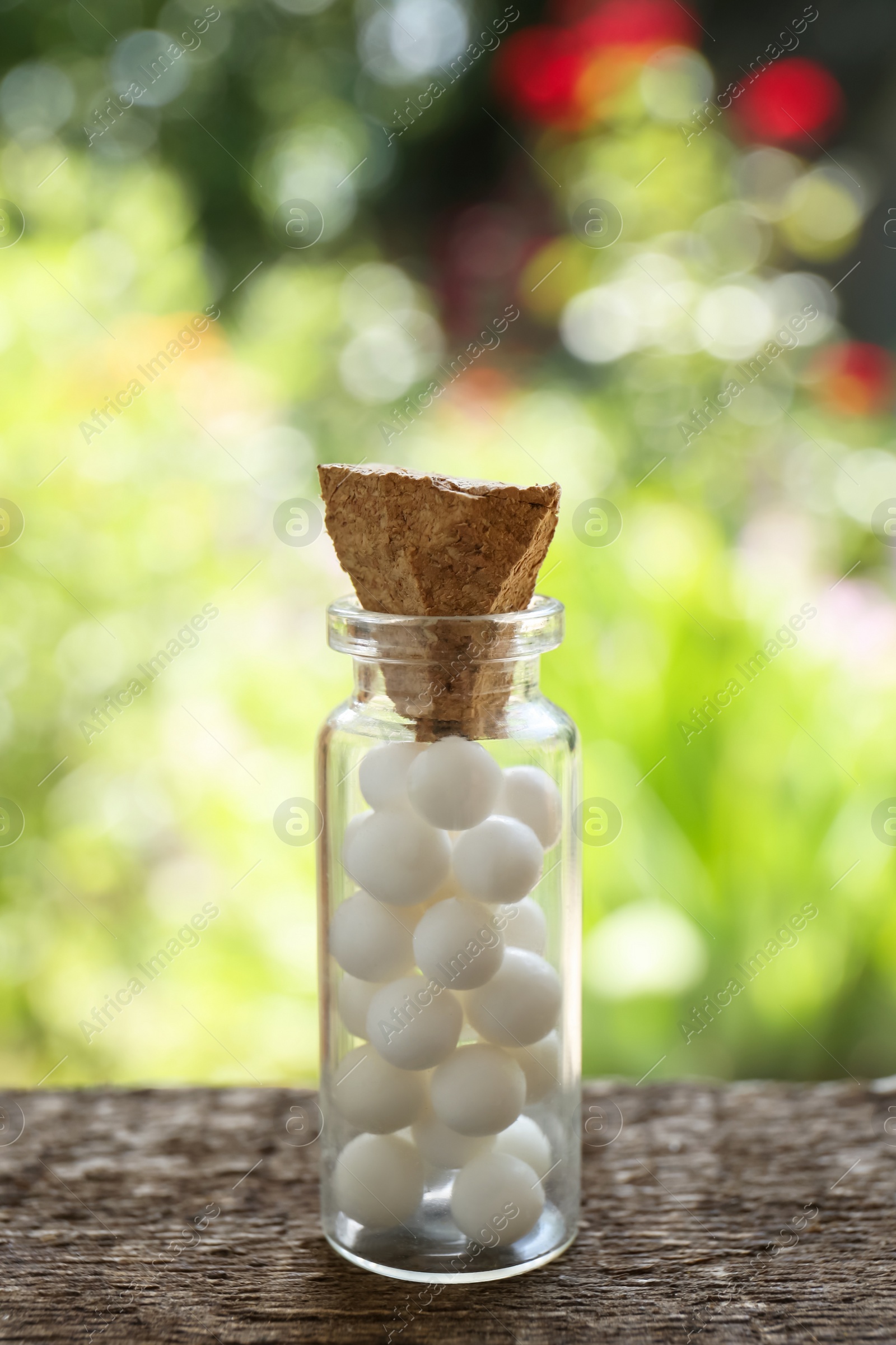 Photo of Bottle of homeopathic remedy on wooden table, closeup