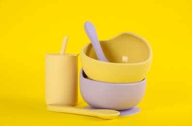 Set of plastic dishware on yellow background. Serving baby food